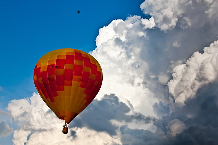 yellow and red hot air balloon near white sky during daytime