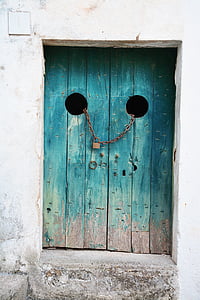 teal wooden door with chain and padlock