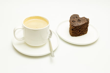 cup of coffee on saucer with teaspoon beside sliced cake