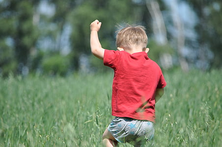 boy running on grass field