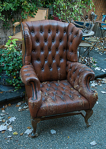 brown leather armchair on black asphalt road