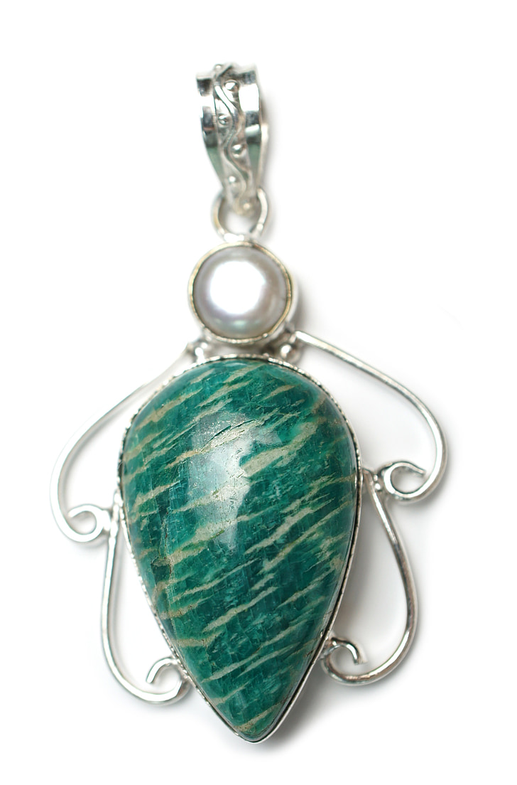 oval green gemstone pendant on white surface