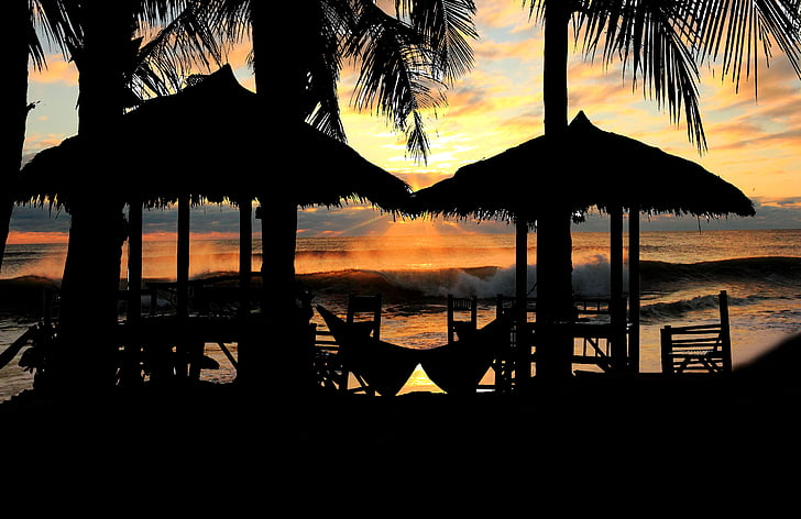 Royalty-Free photo: Silhouette of hut near seashore at golden hour - PickPik