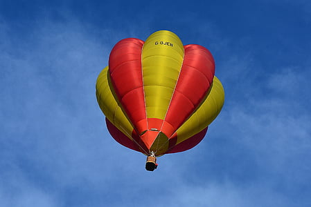 worm's eyeview of yellow and red hot air balloon during daytime