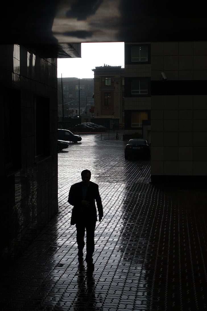 silhouette of man walking inside building