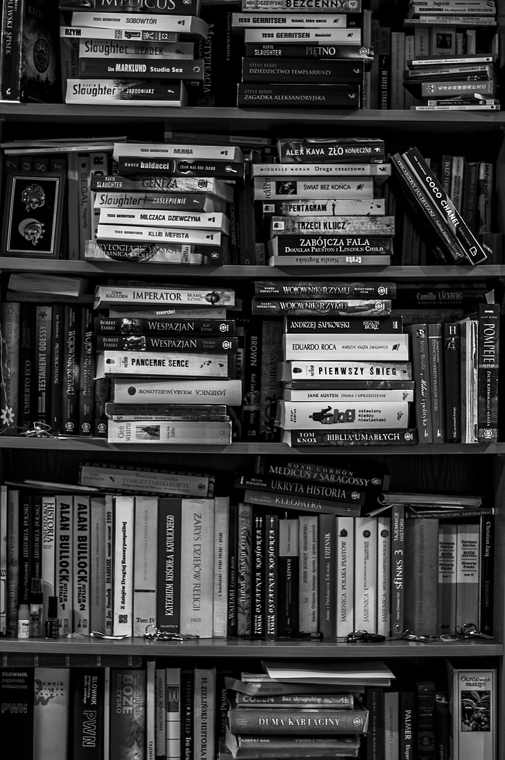 grayscale photo of piled books