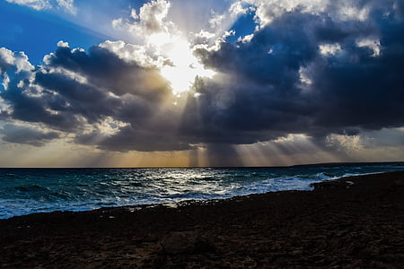 photography of calm sea under crepuscular rays