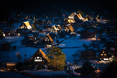 snow covered town with lights during night time