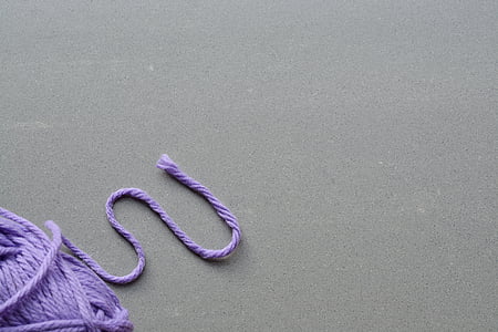 purple yarn on top of gray concrete
