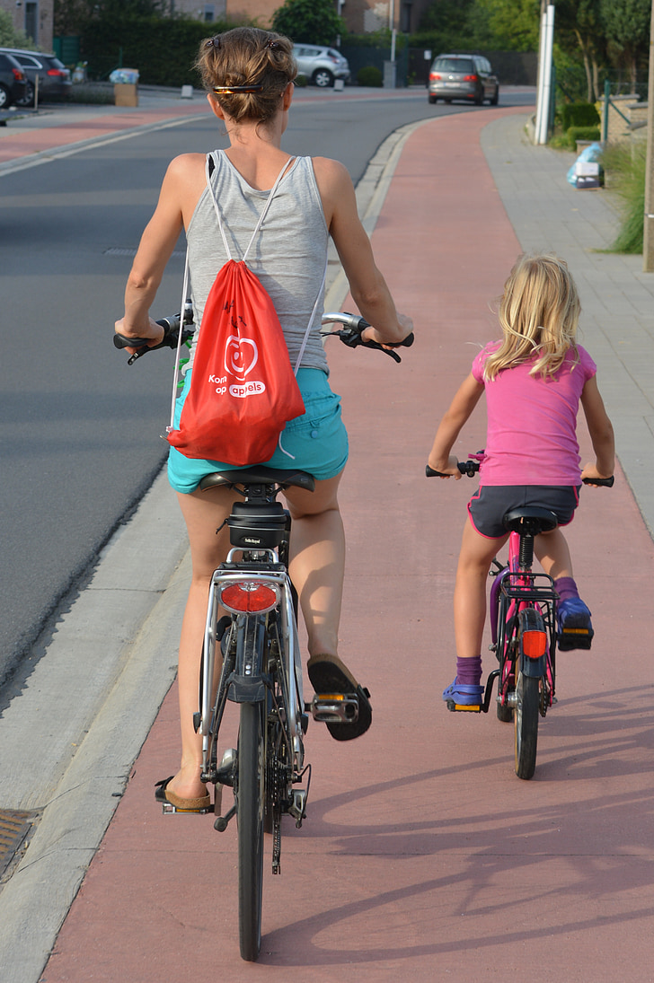 lady riding bike with baby in bag