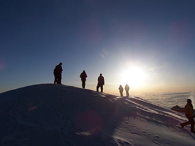 silhouette of group of people on top of mountain