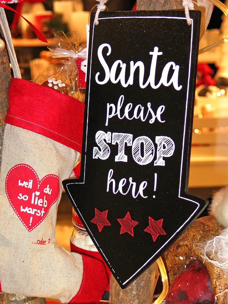 Santa Please Stop Here signage beside christmas stocking