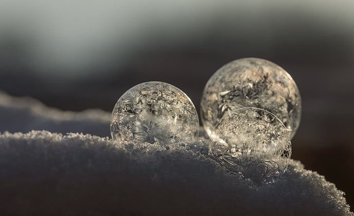 three round ornaments on snow closeup photo