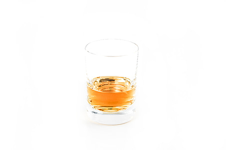 clear shot glass with brown liquid