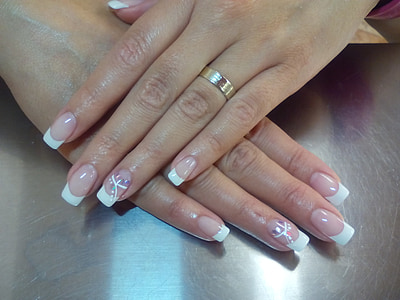 woman wearing gold-colored ring and white French-tip manicures