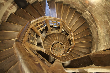 shallow focus photo of brown wooden spiral stairs