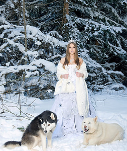 woman wearing white dress and coat standing near two wolves