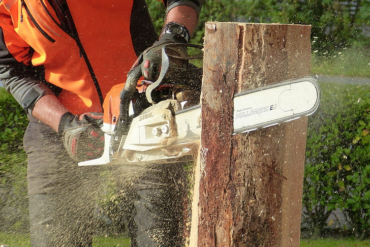 man using chainsaw cutting tree log