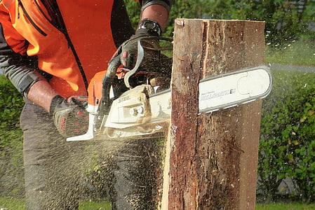 man using chainsaw cutting tree log