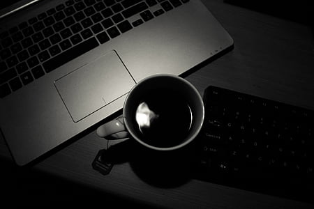 white ceramic mug filled with coffee near laptop computer