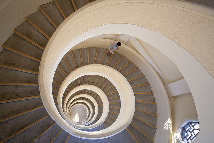 boy going down a spiral concrete staircase