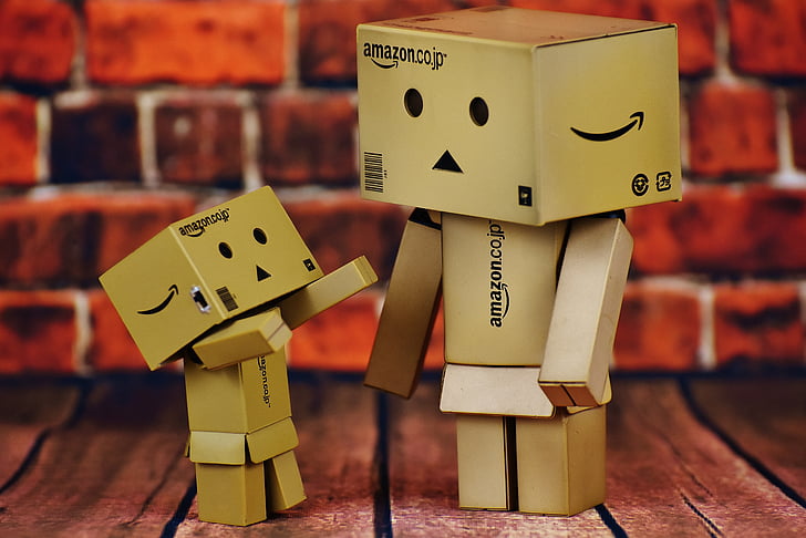 two Amazon box figure on brown wooden board