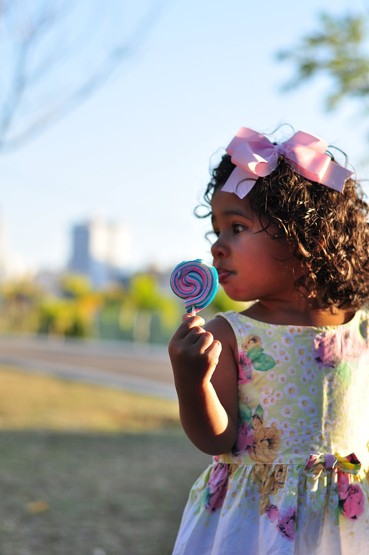 girl's holding multicolored lollipop