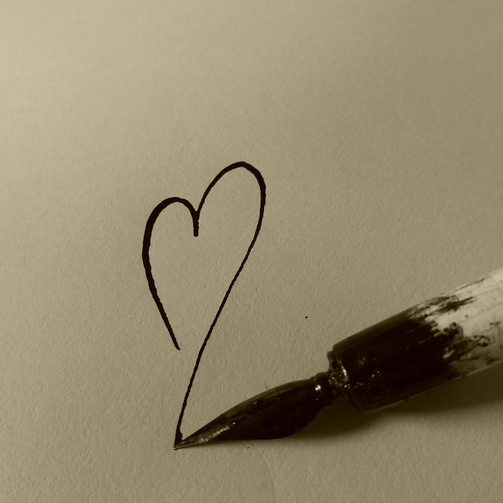 black and white paint brush draws heart on paper
