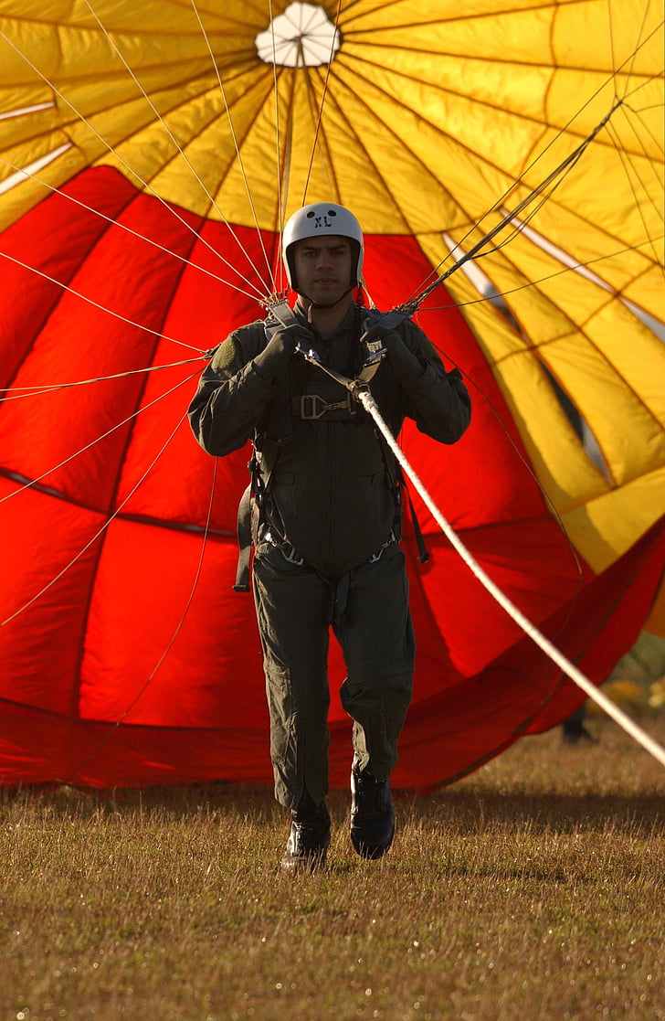 man wearing black overall pants and white half helmet using parachute