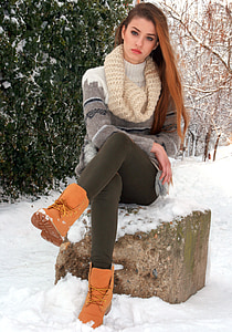 sitting woman wearing white knit cowl and brown work boots