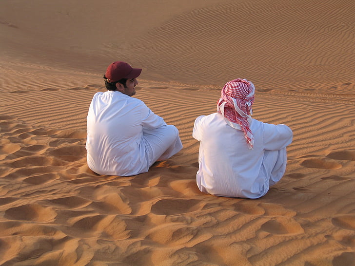 two man sitting on desert