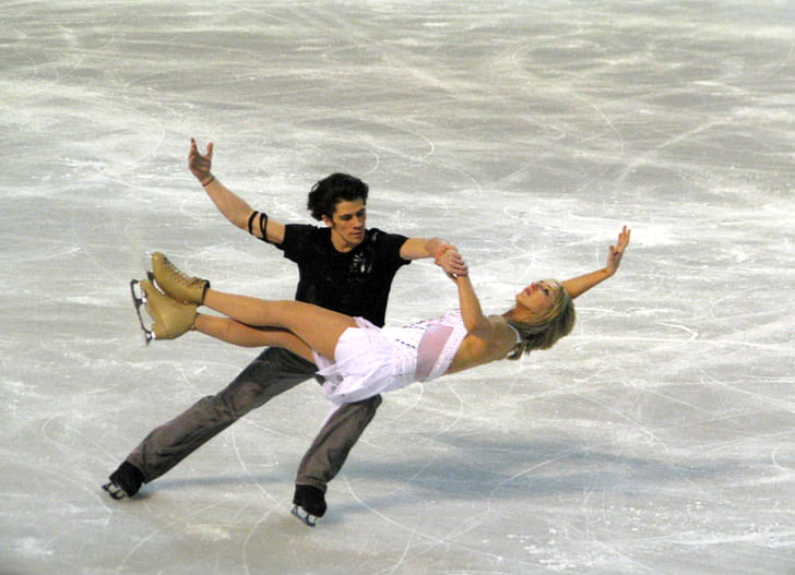 man and woman performing ice skates