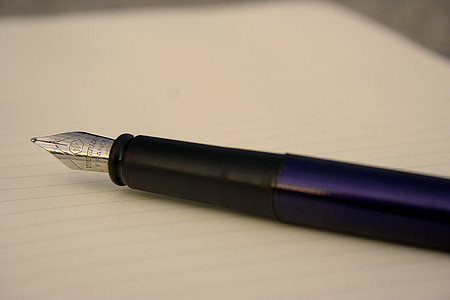 shallow focus photography black and purple fountain pen