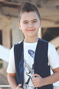 boy in black vest and white crew-neck t-shirt