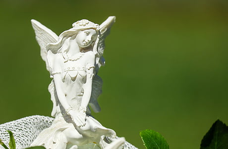 white ceramic angel figurine in closeup photography