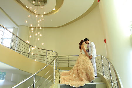 man and woman standing on staircase near chandelier