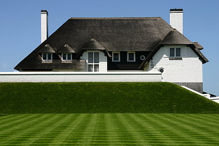 white and gray house with trimmed lawn
