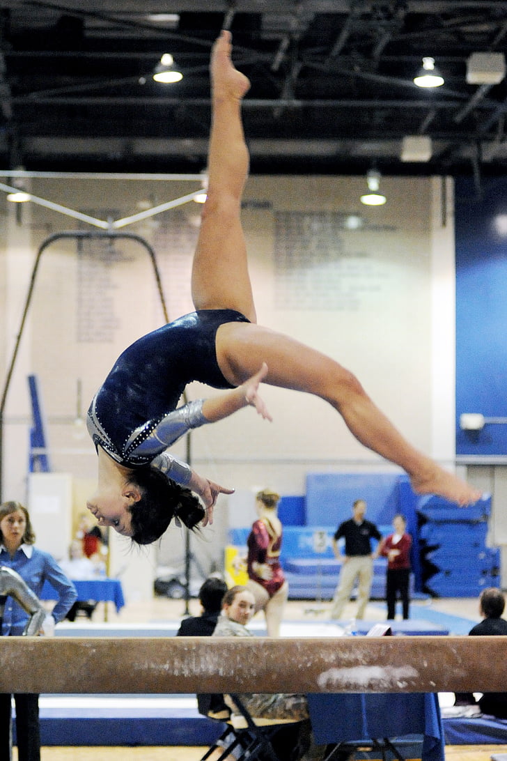 gymnast back flipping on beam