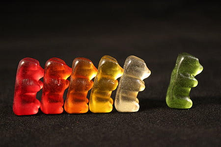assorted-color gummy bears on black surface