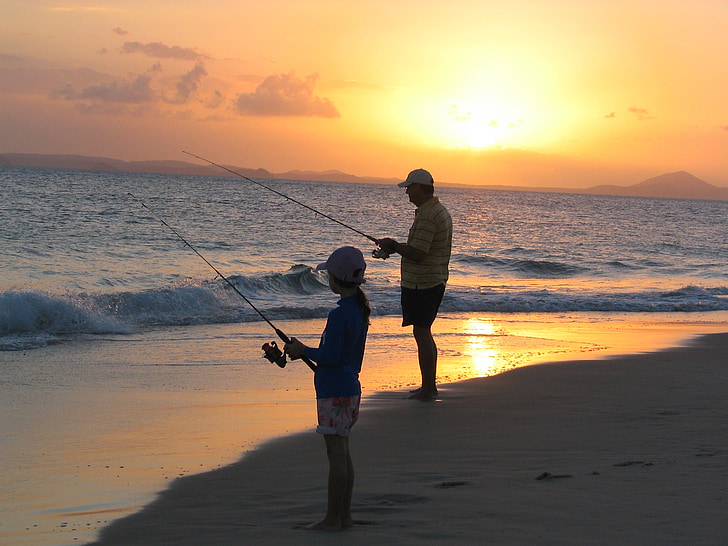 boy and man fishing on the seashore