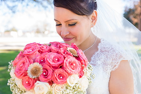 woman in wedding dress holding pink and white rose bouquet