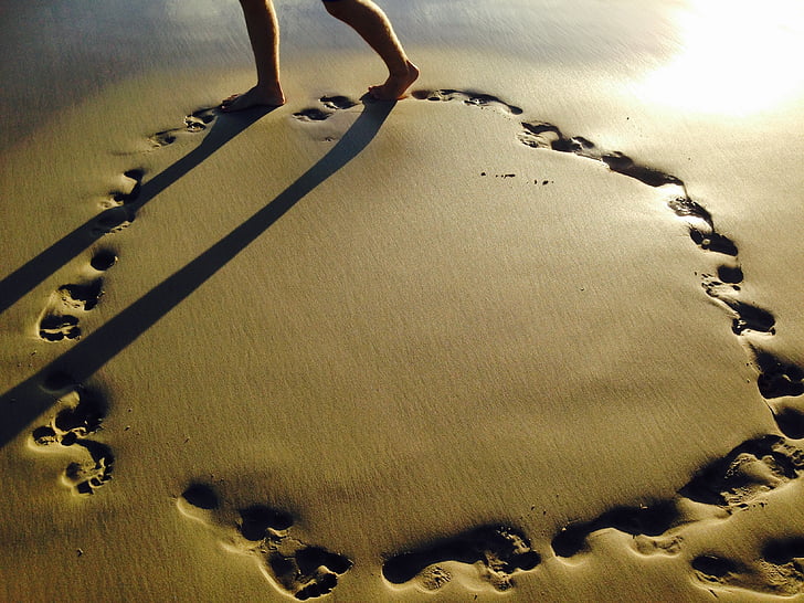 person walking on beach sand