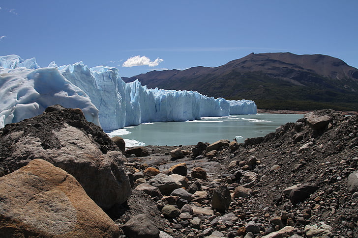 iceberg beside body of water and mountains during daytime