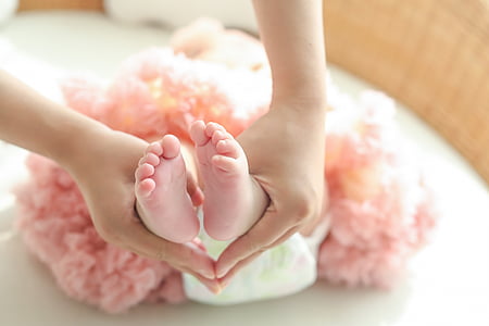 person holding baby foots selective focus photography
