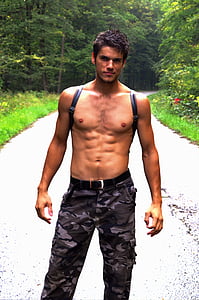 photograph of topless man in front of road