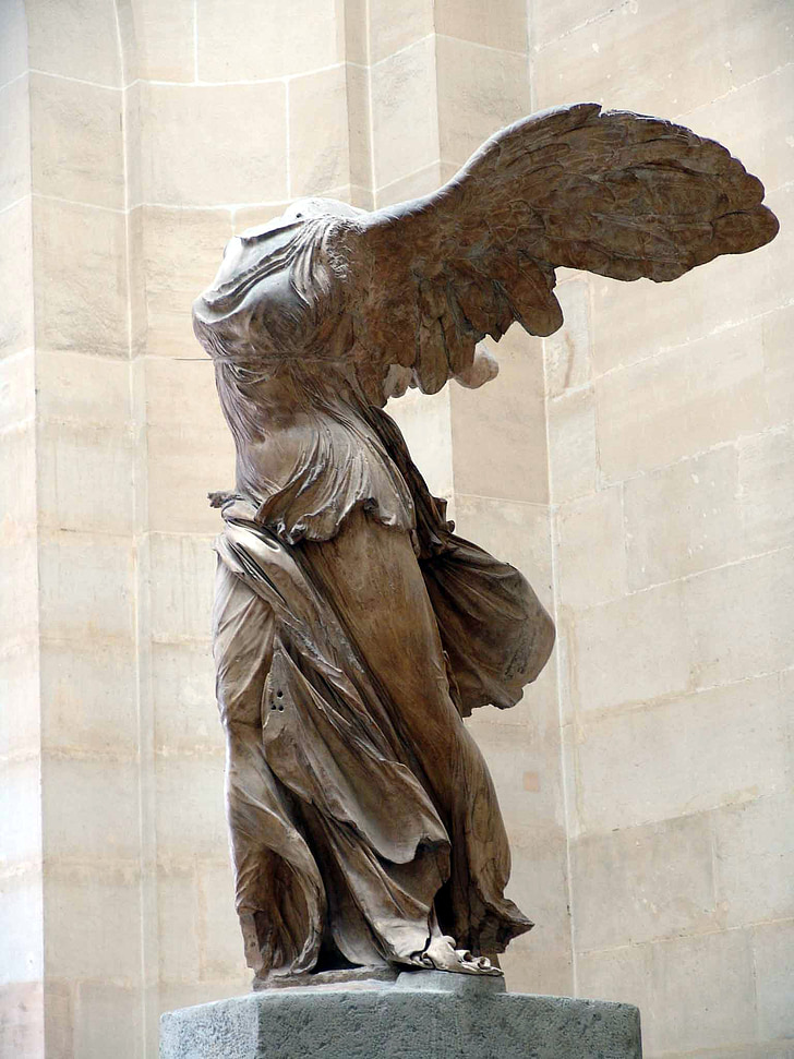 angel statue near white wall