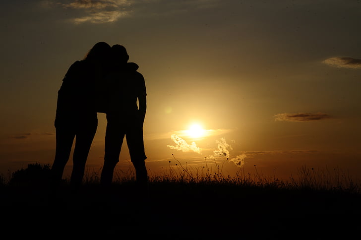 silhouette of two people on grass