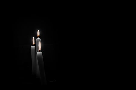 grayscale photography of three white lighted candles