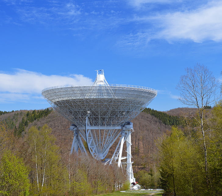 white satellite covered in green leafed trees under blue skyt
