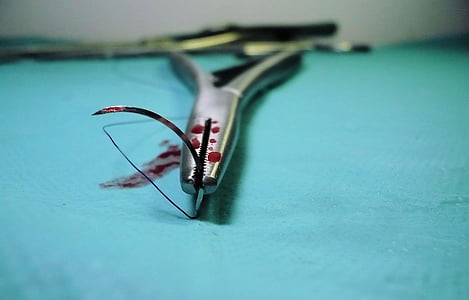 gray operating needle with blood stain